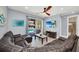 Cozy living room with a large leather sectional, ceiling fan, and sliding door leading to the pool area at 640 Lasso Dr, Kissimmee, FL 34747