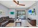 Cozy living room with a large sectional sofa, ceiling fan, and a view of the outdoor pool area at 640 Lasso Dr, Kissimmee, FL 34747