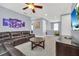 Cozy living room features a leather sectional sofa, ceiling fan, and large television at 640 Lasso Dr, Kissimmee, FL 34747