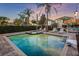 An in-ground pool with a spa, tiki bar, basketball hoop, and mature landscaping in the backyard at 640 Lasso Dr, Kissimmee, FL 34747
