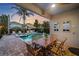 Outdoor patio offering seating with a view of the backyard pool, tiki bar, and lush landscaping at 640 Lasso Dr, Kissimmee, FL 34747