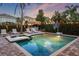 An inviting pool and hot tub area with tropical landscaping, a tiki bar, and lounge seating at 640 Lasso Dr, Kissimmee, FL 34747