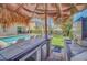 Outdoor poolside bar area featuring a tiki hut roof, a tv, a bar, and lounge chairs at 640 Lasso Dr, Kissimmee, FL 34747