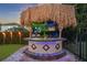 Outdoor tiki bar with a thatched roof, lighting, counter, and grill area for entertaining at 640 Lasso Dr, Kissimmee, FL 34747