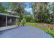 Spacious backyard with a large wooden deck, lush greenery, and a well-maintained lawn, ideal for outdoor activities at 750 W May St, Deland, FL 32720