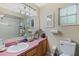 Well-lit bathroom with a large mirror, neutral wall color, a single sink vanity, and a toilet and shower combination at 750 W May St, Deland, FL 32720