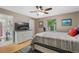 Comfortable bedroom with a ceiling fan, dresser with a TV on top, and an open door to an ensuite bathroom at 750 W May St, Deland, FL 32720