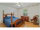 Cozy bedroom with vintage wallpaper, traditional wooden furniture, and a window overlooking a peaceful street at 750 W May St, Deland, FL 32720