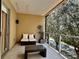 This balcony features glass railings, cozy seating, and serene views of lush trees, creating a perfect outdoor escape at 7667 Recife Dr, Kissimmee, FL 34747