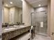 Bathroom featuring double sinks with granite countertops, vanity seating, and a glass shower at 7667 Recife Dr, Kissimmee, FL 34747