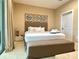 Comfortable bedroom featuring king bed, neutral decor, decorative wall art and a sliding glass door at 7667 Recife Dr, Kissimmee, FL 34747
