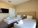 Inviting bedroom featuring two twin beds and a mounted television at 7667 Recife Dr, Kissimmee, FL 34747