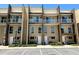 Modern townhome exterior with a glass balcony, lush landscaping and convenient parking spaces at 7667 Recife Dr, Kissimmee, FL 34747