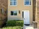 Inviting townhome exterior with a modern front door, manicured landscaping, and stylish light fixtures at 7667 Recife Dr, Kissimmee, FL 34747