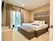 This luxurious main bedroom features sliding glass doors, a king bed and decorative wall art at 7667 Recife Dr, Kissimmee, FL 34747