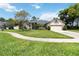 Inviting home featuring a well-kept lawn, mature trees, and a concrete walkway at 802 Kaywood Dr, Orlando, FL 32825