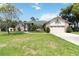 Well-maintained home featuring a green lawn, manicured landscaping, and mature trees at 802 Kaywood Dr, Orlando, FL 32825