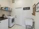 Functional laundry room with washer, dryer, sink, and storage shelving at 802 Kaywood Dr, Orlando, FL 32825