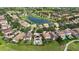 An aerial view of a neighborhood with a lake and houses that have tile roofs, pools, and solar panels at 8312 Prestbury Dr, Orlando, FL 32832