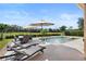 Backyard patio featuring a pool, lounge chairs, dining table, and umbrella at 8312 Prestbury Dr, Orlando, FL 32832