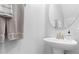 Simple powder room featuring a pedestal sink with toiletries and a round mirror above at 8312 Prestbury Dr, Orlando, FL 32832