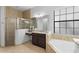 Modern bathroom featuring a glass shower, granite vanity, and soaking tub by the window at 8312 Prestbury Dr, Orlando, FL 32832