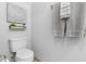 Light and airy powder room featuring a standard toilet, minimalist shelf, and neatly arranged towels at 8312 Prestbury Dr, Orlando, FL 32832