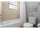 Bright bathroom featuring tiled shower and tub combination with neutral color scheme at 8312 Prestbury Dr, Orlando, FL 32832