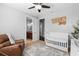 Light-filled Bedroom with a crib, chair, and view into adjacent bathroom at 8312 Prestbury Dr, Orlando, FL 32832