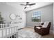 Cozy Bedroom features a crib, changing table, comfortable chair, and natural light at 8312 Prestbury Dr, Orlando, FL 32832
