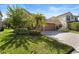 A beautiful house with a well-kept lawn, a brick driveway, a two-car garage, and some landscaping at 8312 Prestbury Dr, Orlando, FL 32832