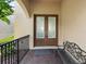 Front entryway has double doors with glass panes, and a wrought iron bench at 8312 Prestbury Dr, Orlando, FL 32832