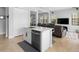 Stylish kitchen island with stainless steel appliances, white cabinetry, and seating overlooks the living area at 8312 Prestbury Dr, Orlando, FL 32832