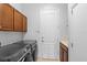 Functional laundry room with front-loading washer and dryer, cabinet storage, and utility sink at 8312 Prestbury Dr, Orlando, FL 32832