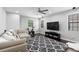 Bright living room features comfortable seating, ceiling fan, large TV and stylish area rug at 8312 Prestbury Dr, Orlando, FL 32832