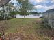 Expansive backyard with mature trees, enclosed by a white fence, offering privacy and outdoor enjoyment at 977 E Normandy Blvd, Deltona, FL 32725
