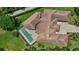 Aerial view of the home showcasing the roof, screened in pool, lush backyard, and driveway at 10352 Burris Ct, Orlando, FL 32836