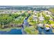 Aerial view showcasing a luxurious waterfront home with dock access, surrounded by mature trees and landscaping at 10352 Burris Ct, Orlando, FL 32836