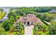 Expansive estate with lush landscaping, circular driveway, and tiled roof as seen from an aerial view at 10352 Burris Ct, Orlando, FL 32836