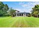 Expansive backyard with lush lawn, mature trees, and a screened-in patio area for relaxation at 10352 Burris Ct, Orlando, FL 32836