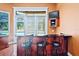 The home bar boasts wood cabinetry, stylish stools, and views of the pool area, creating a relaxing entertainment space at 10352 Burris Ct, Orlando, FL 32836