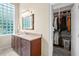 Bathroom vanity with granite countertop, mirror and a view of the closet at 10352 Burris Ct, Orlando, FL 32836