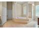 Bright bathroom boasts a luxurious soaking tub encased by pillars, and tiled floor at 10352 Burris Ct, Orlando, FL 32836