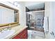 Bathroom with a vanity, a gold-framed mirror, and a tiled walk-in shower with a glass door at 10352 Burris Ct, Orlando, FL 32836