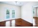 Hardwood floor bedroom, ceiling fan, and double glass doors to a balcony at 10352 Burris Ct, Orlando, FL 32836