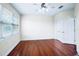 Bright bedroom with hardwood floors, ceiling fan, large window, and white trim, offering a clean, inviting space at 10352 Burris Ct, Orlando, FL 32836