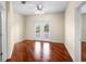 A spacious bedroom with shining hardwood floors has ample lighting and neutral paint at 10352 Burris Ct, Orlando, FL 32836