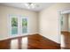 An airy bedroom with shining hard wood floors leads out to a balcony through double glass doors at 10352 Burris Ct, Orlando, FL 32836