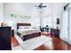 A bright and airy main bedroom offers elegant furnishings, a soaring ceiling, and gleaming hardwood floors at 10352 Burris Ct, Orlando, FL 32836