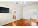 Bedroom view showcasing hardwood floors, a mounted TV, and multiple doors at 10352 Burris Ct, Orlando, FL 32836